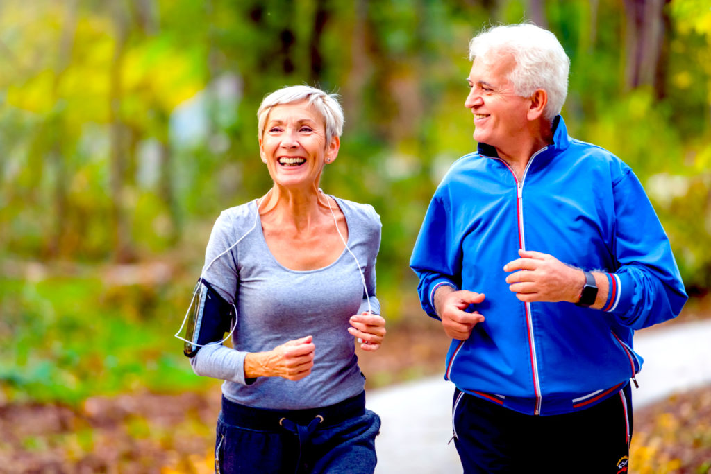 Älteres Ehepaar joggt lachend