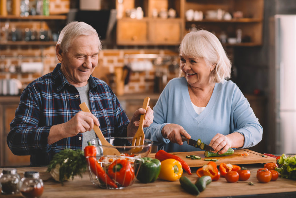 Älteres Ehepaar macht zusammen Salat